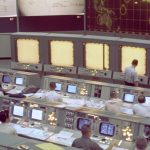 Overall view of the Mission Control Center (MCC), Houston, Texas, during the Gemini 5 flight. Note the screen at the front of the MCC which is used to track the progress of the Gemini spacecraft.