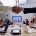 Two people shaking hands in a meeting