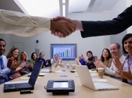 Two people shaking hands in a meeting