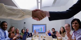 Two people shaking hands in a meeting