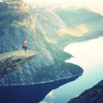 A person doing yoga poses on a cliff