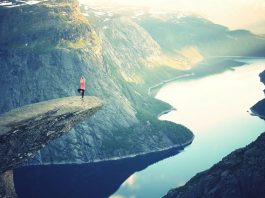 A person doing yoga poses on a cliff