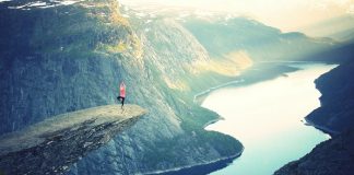 A person doing yoga poses on a cliff