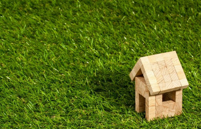 toy wooden house on some grass